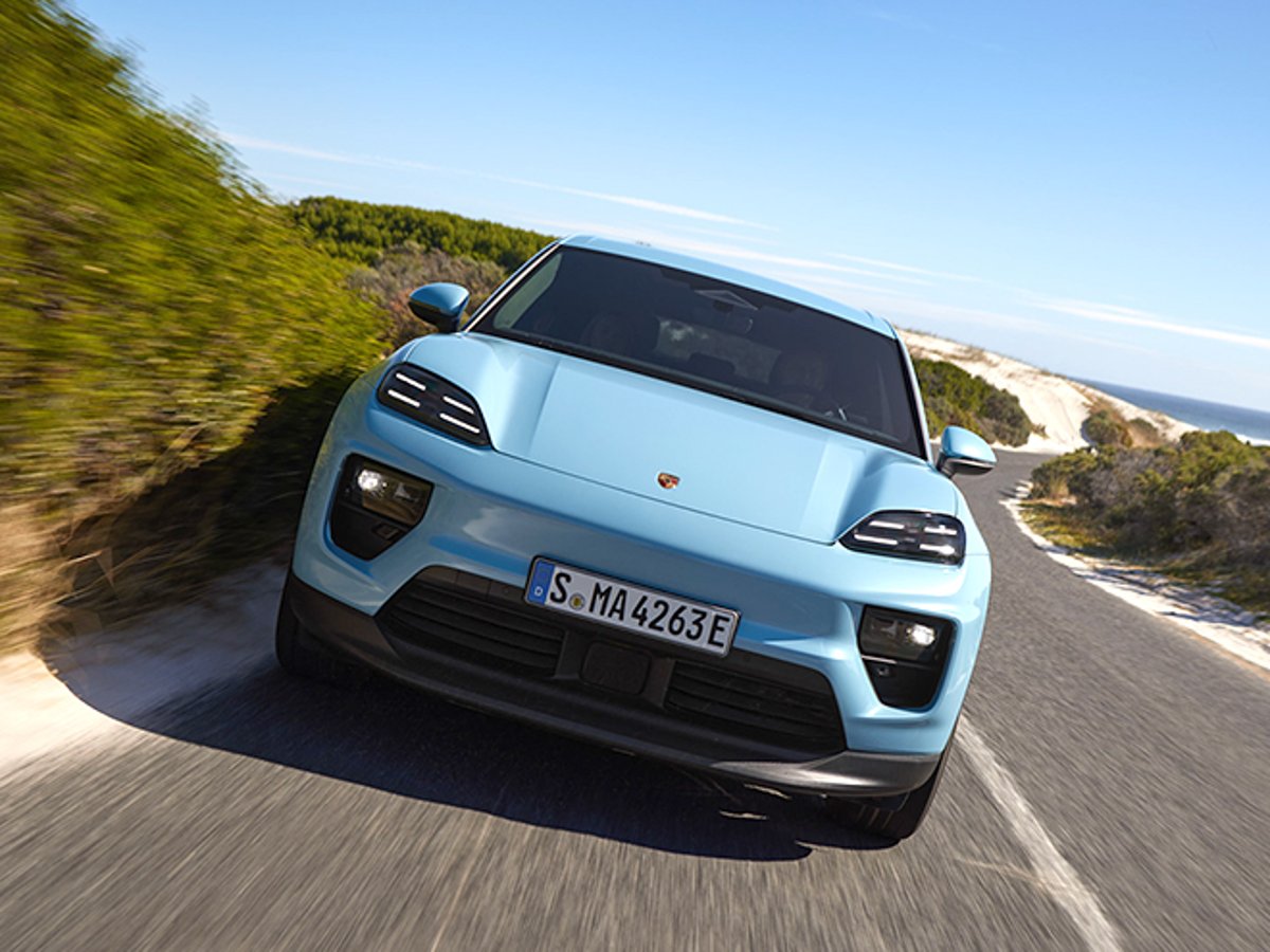 Porsche Macan Electric driving on a coastal road